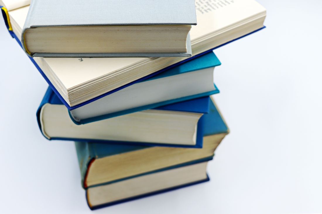 Stack of blue hardcover books on white