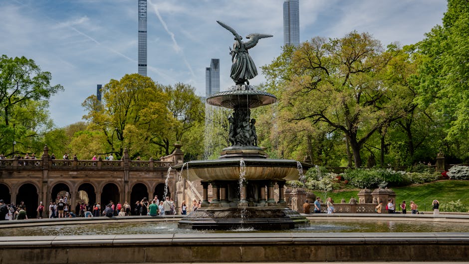 Scenic view of Bethesda Fountain in Central Park on a sunny day with visitors around.