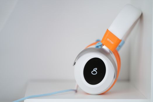 Close-up of stylish orange headphones featuring an infinity symbol on the ear cup.