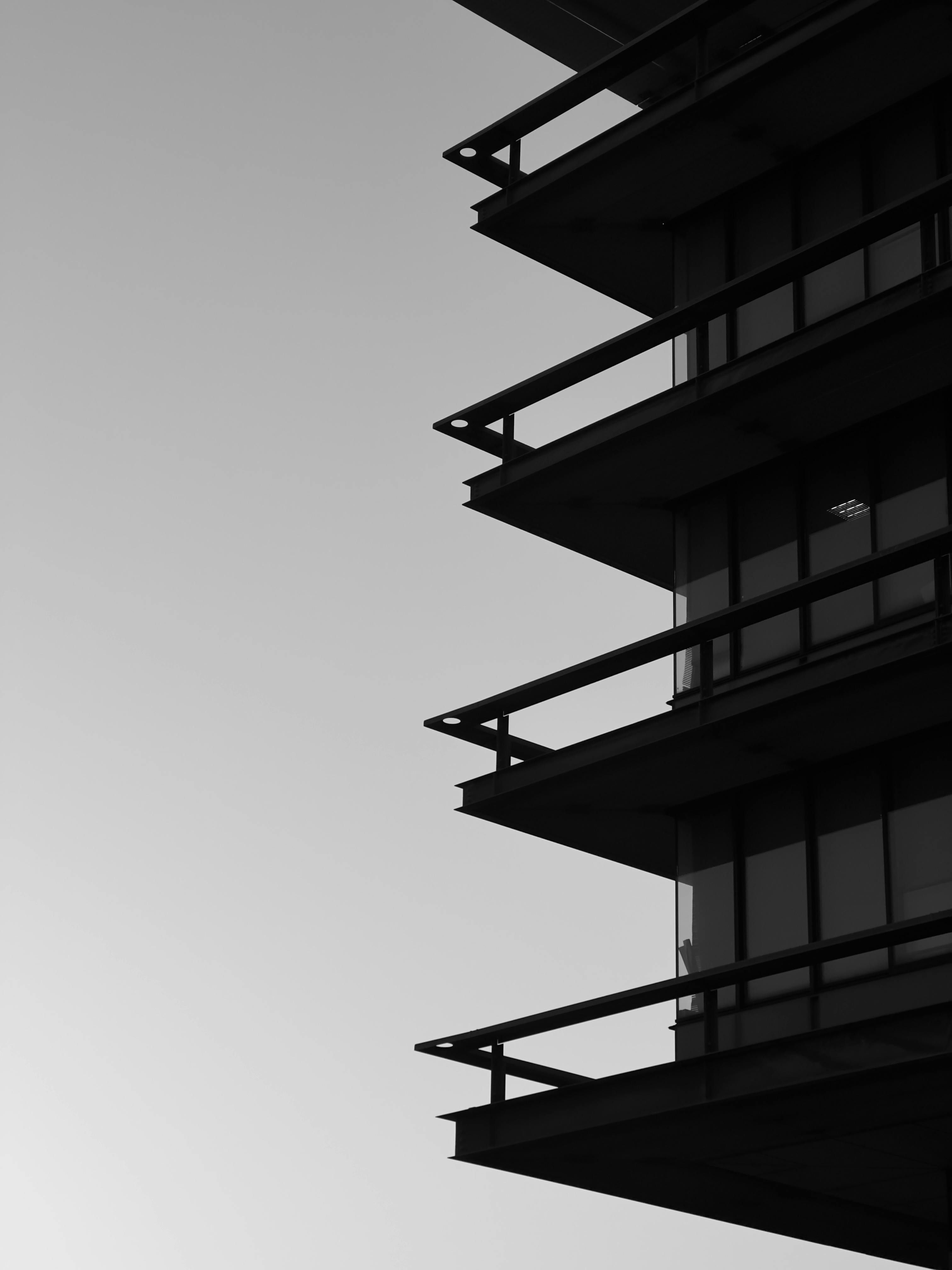 Kostenlos Ein Schwarzweißfoto der Silhouette eines modernen Gebäudes vor dem Himmel. Stock-Foto