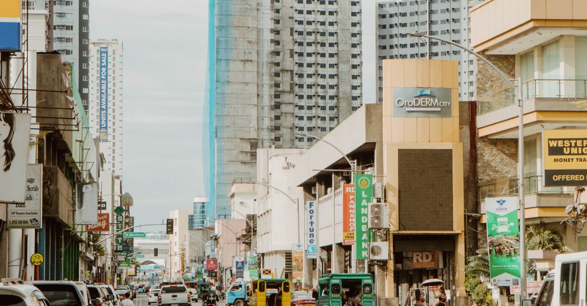 Dynamic urban landscape of Davao City featuring busy streets and towering buildings.