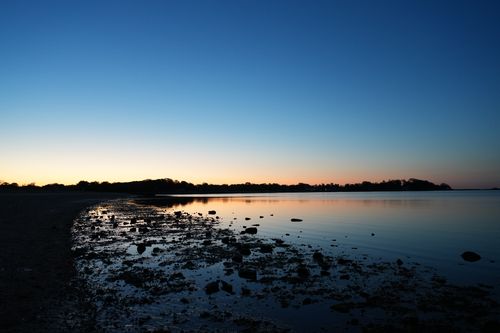 Free Breathtaking sunrise view over Cove Island Park, Stamford with calm waters and silhouetted landscape. Stock Photo