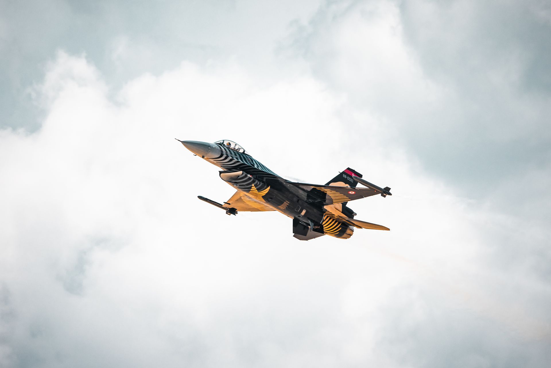 Modern military aircraft soaring among clouds, showcasing advanced aerodynamics.