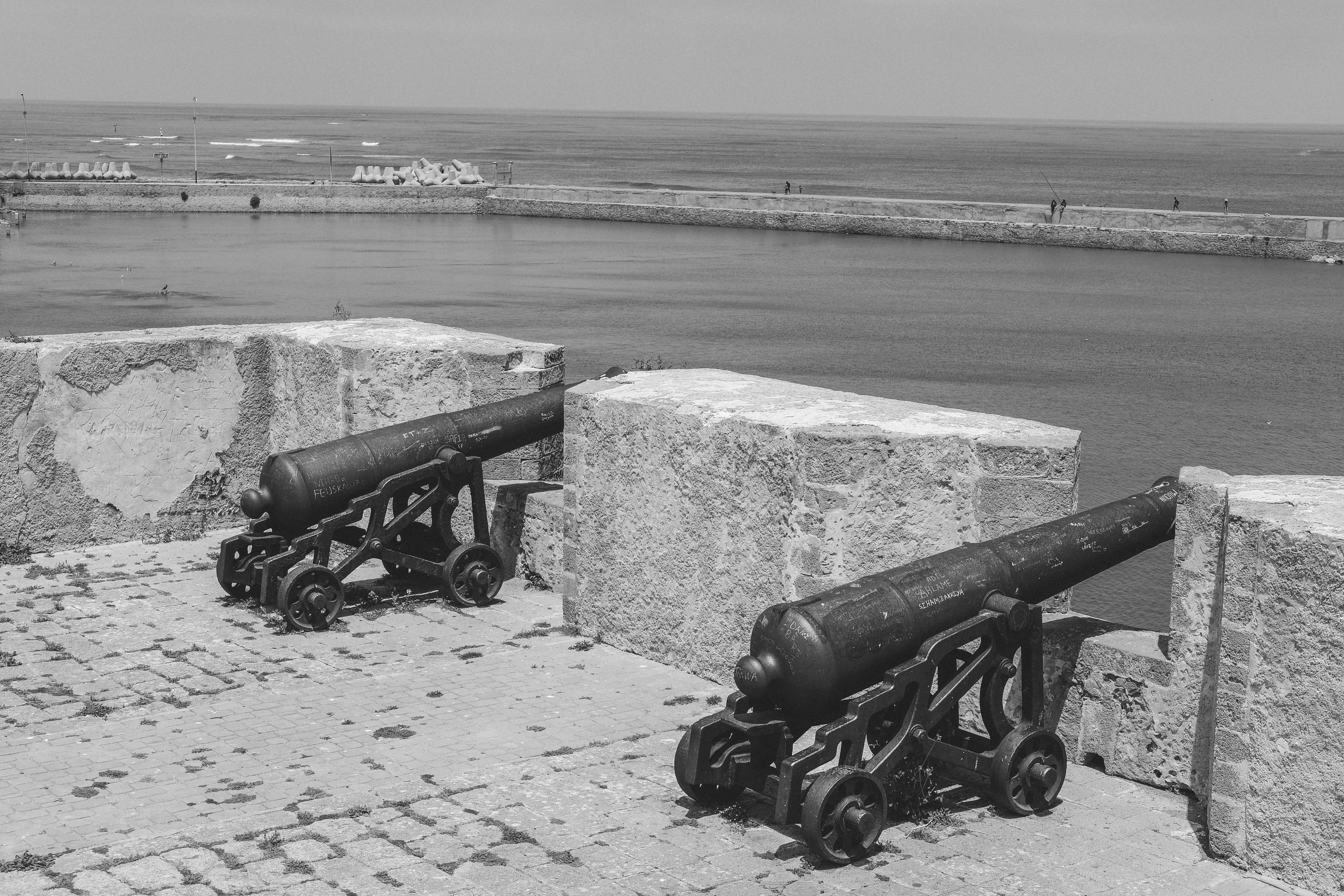 Black and white photo of historic cannons by the Atlantic Ocean in El Jadida, Morocco.