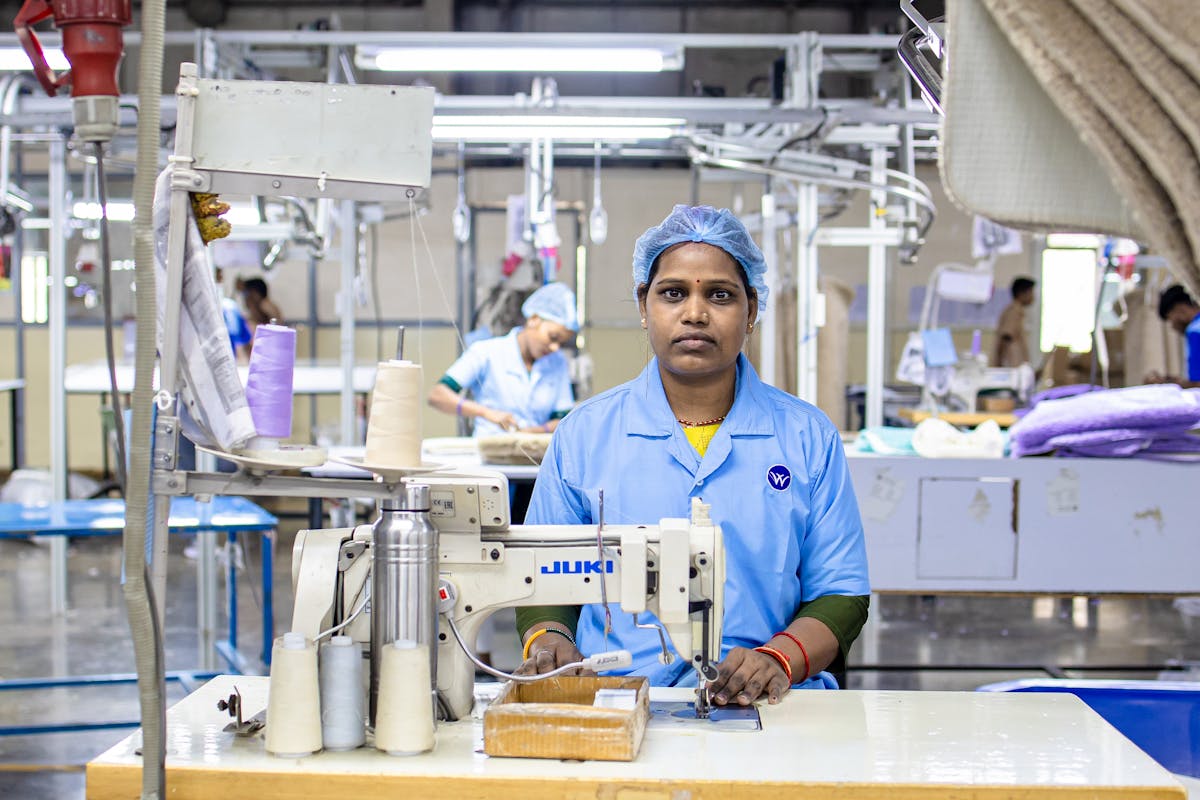 Worker operating a sewing machine in a garment factory