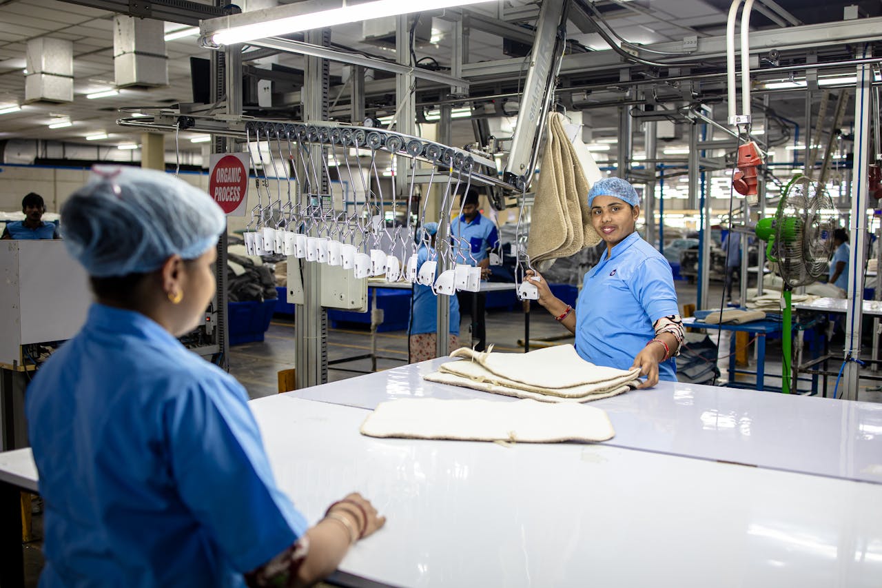 Lavoratori tessili in linea di produzione che organizzano tessuti con sistema automatizzato