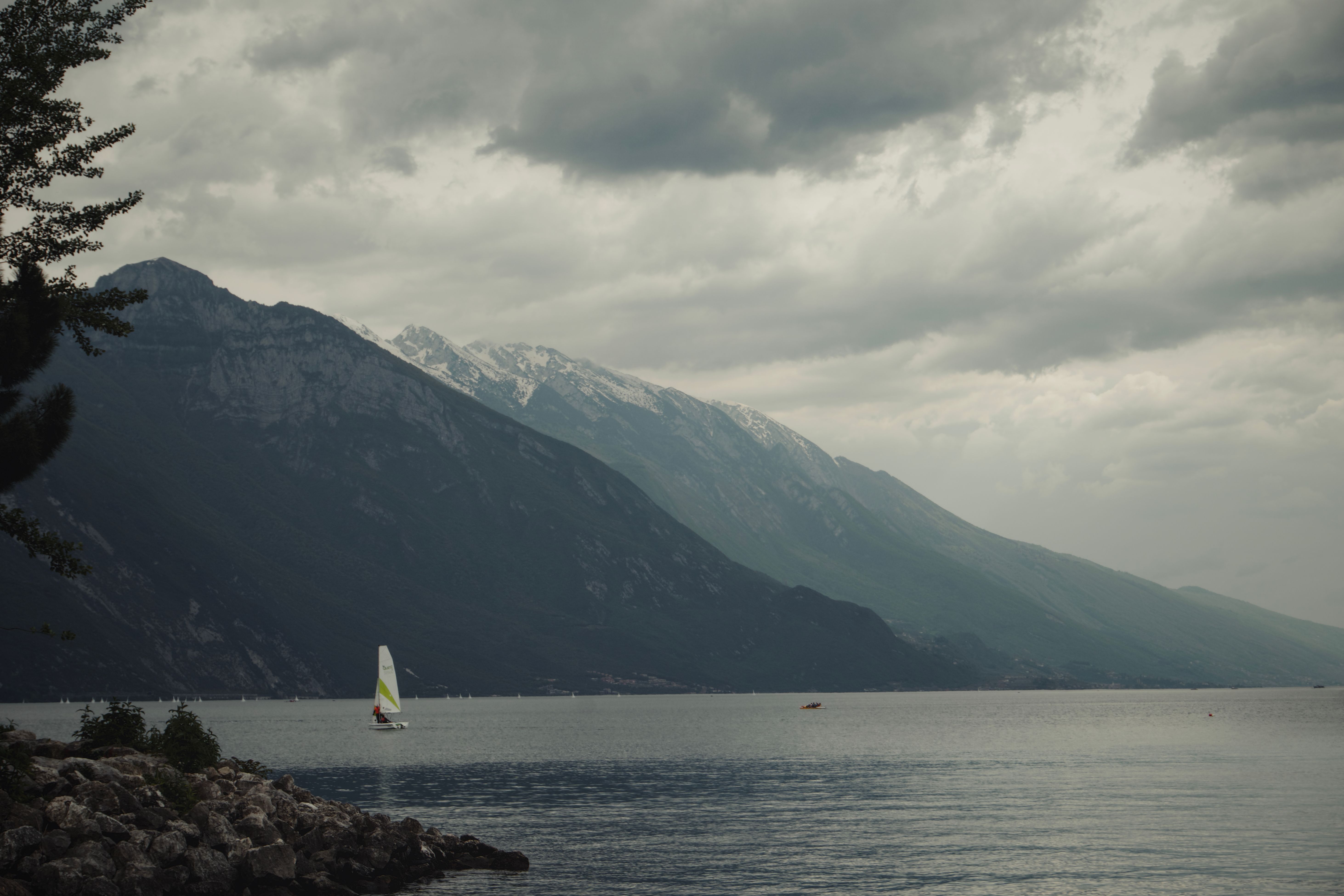 Sailboat on Scenic Mountain Lake under Cloudy Skies · Free Stock Photo