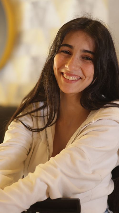 Free Portrait of a smiling woman seated indoors, exuding warmth and comfort. Stock Photo