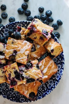 Indulge in artisanal blueberry lemon cake bars on a decorative blue plate.
