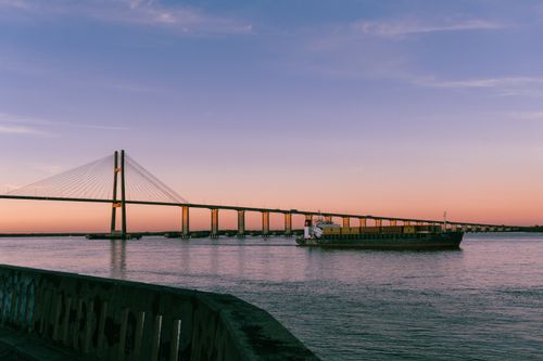 Free Dramatic sunset over Rosario's bridge with a ship passing underneath, captured in vivid colors. Stock Photo