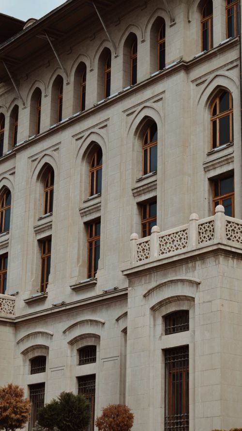 Free Elegant historic building facade featuring arched windows and ornate design elements. Stock Photo