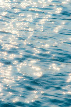 Serene image of sunlight sparkling on a gentle water surface, evoking tranquility and calm.