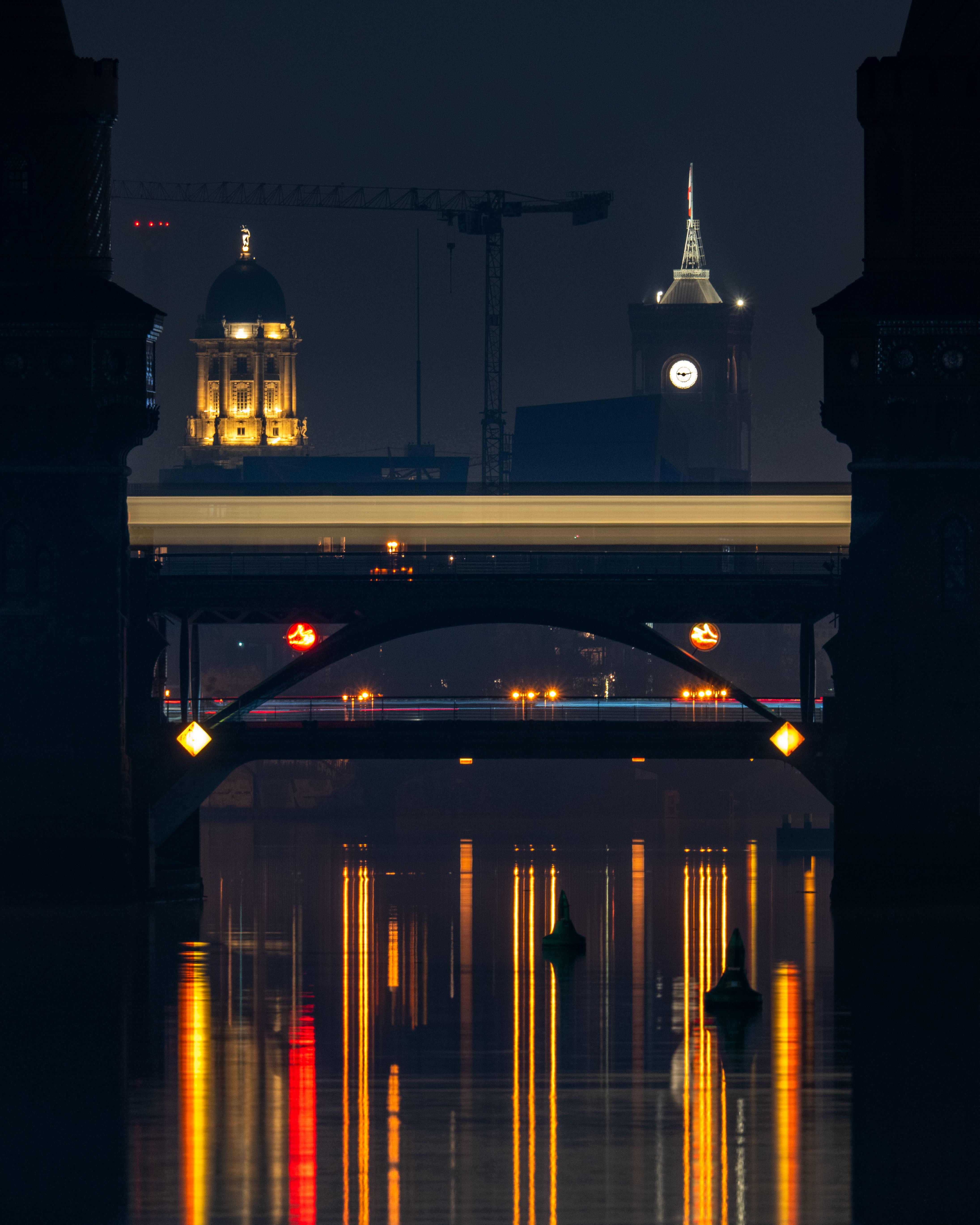 Stunning nighttime capture of Oberbaum Bridge in Berlin reflecting vibrant city lights.