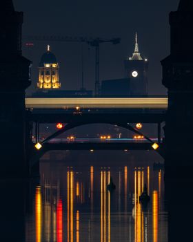 Stunning nighttime capture of Oberbaum Bridge in Berlin reflecting vibrant city lights.