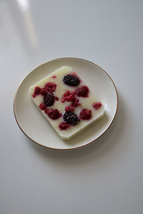 Free A stylish plate featuring a dessert adorned with fresh raspberries and blackberries. Stock Photo
