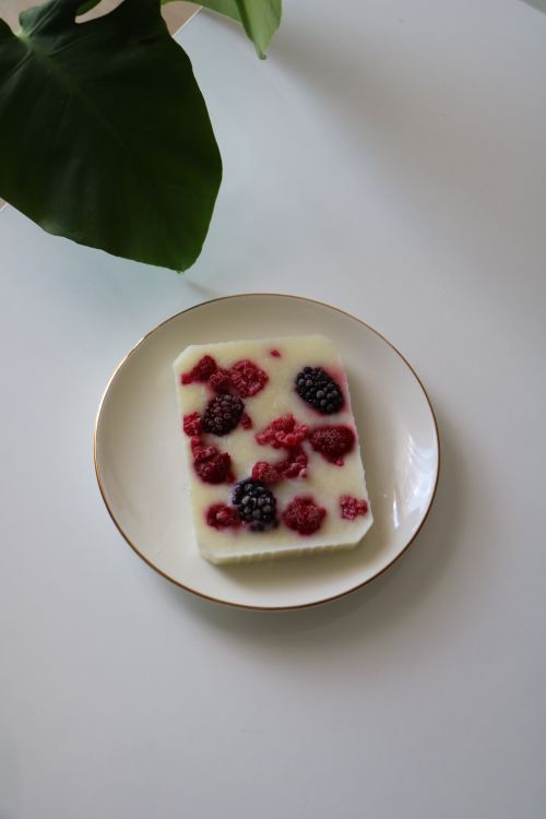 Free Delicious white yogurt bar garnished with fresh blackberries and raspberries on a plate. Stock Photo