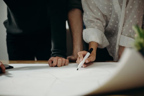 Two People Leaning on Table