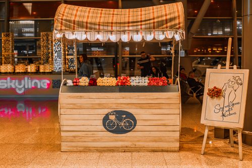 Free A charming flower stall with roses and a wooden design indoors at a modern venue, offering a welcoming atmosphere. Stock Photo