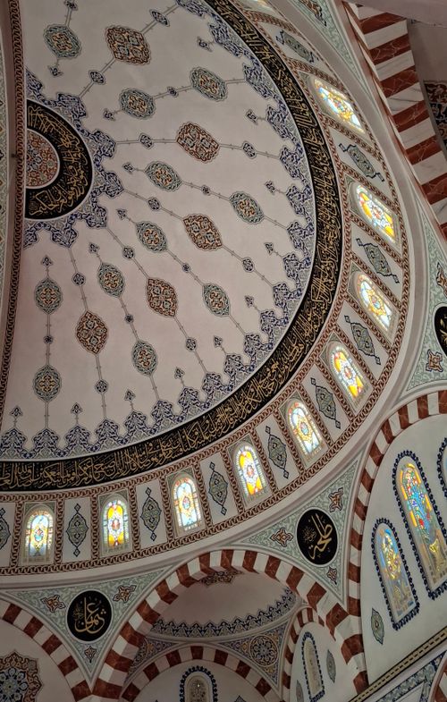 Free Beautifully detailed mosque ceiling decorated with unique patterns and stained glass windows. Stock Photo