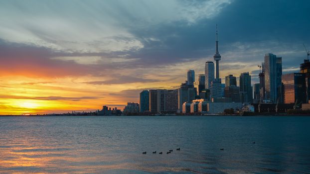 Stunning view of Toronto's skyline during a vibrant winter sunset over Lake Ontario.
