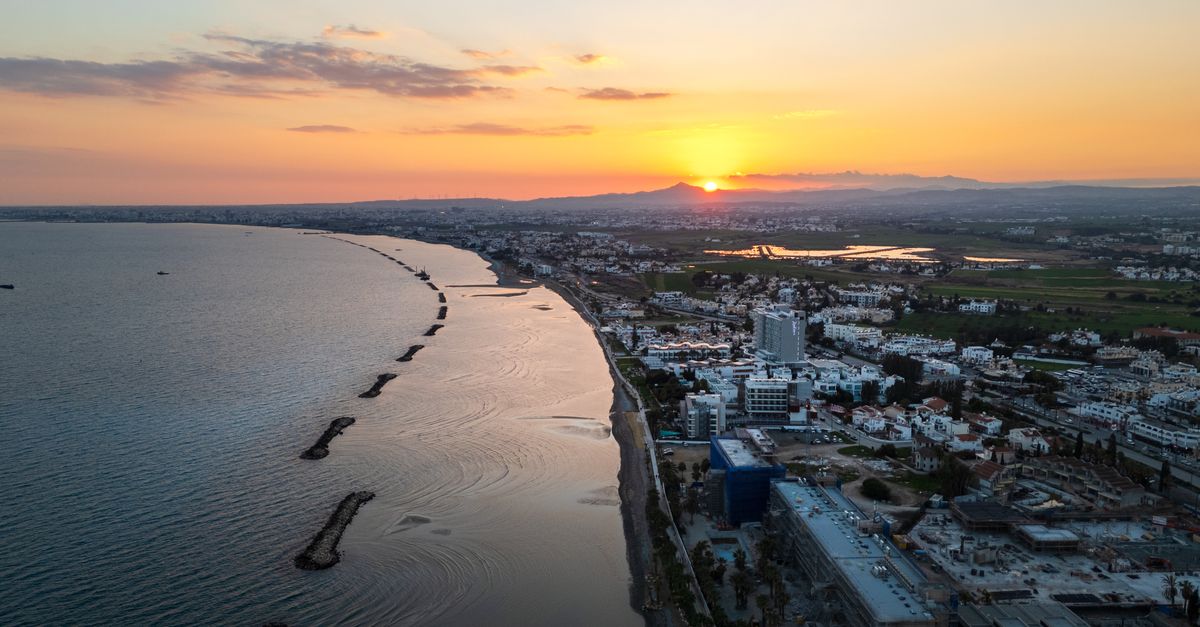 Aerial view of Limassol's coastline during sunset, showcasing the vibrant city and serene sea.