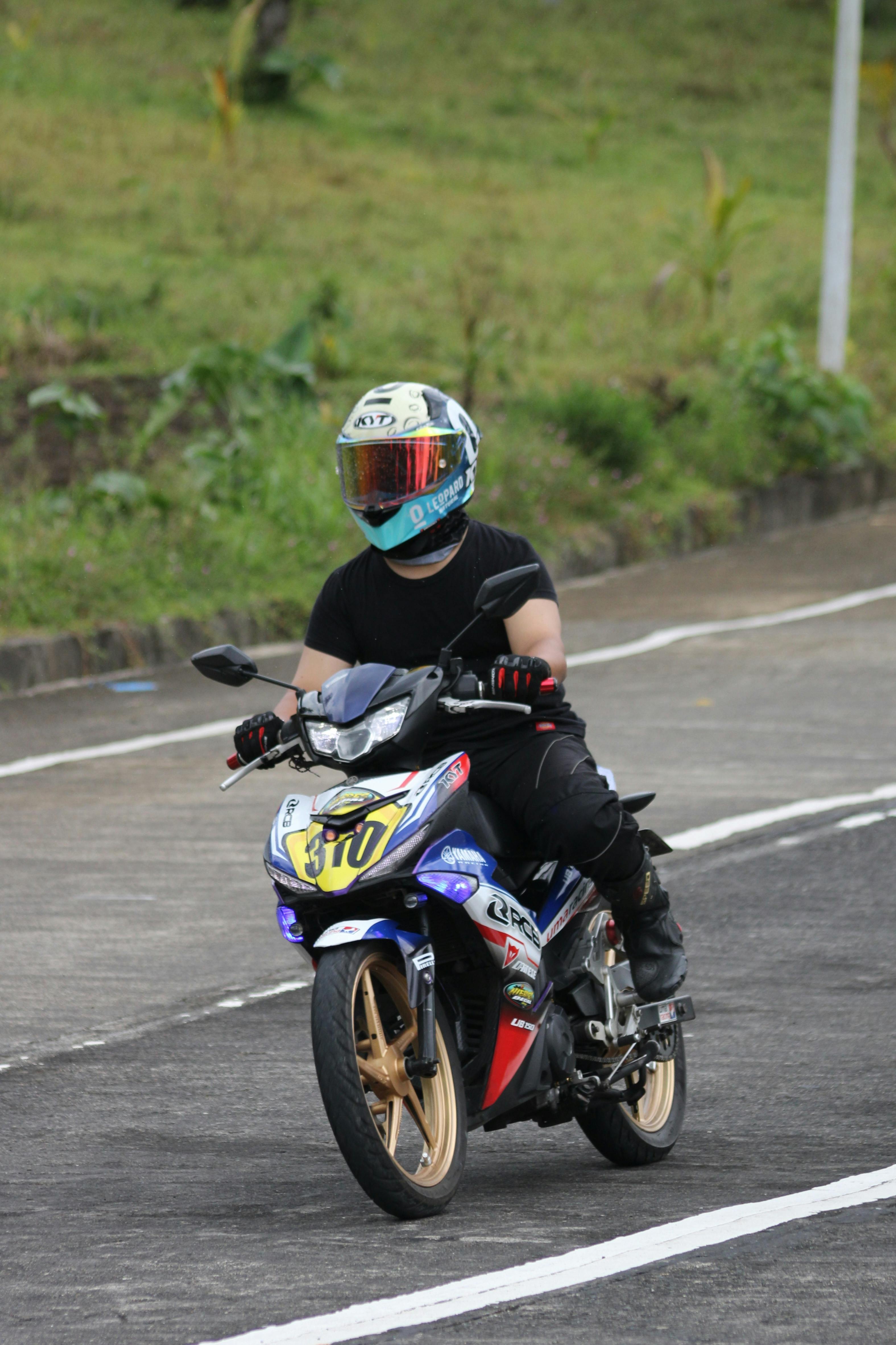 A motorcyclist in protective gear riding on a curved outdoor track.