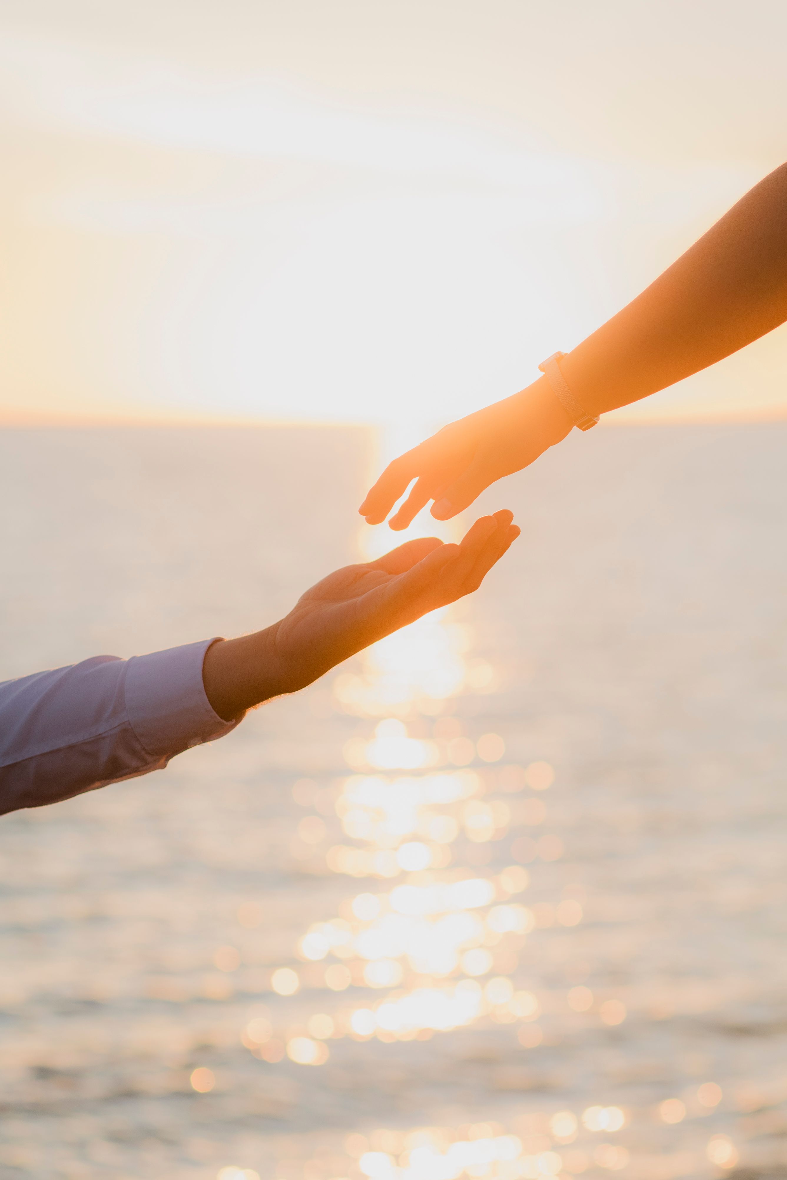 Captivating image of hands reaching out against a sunset in Sinaloa, evoking love and connection.