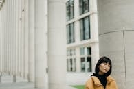 时尚女性在户外以现代城市建筑为背景摆姿势