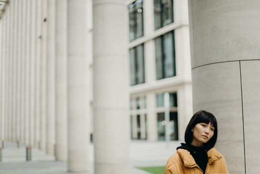 时尚女性在户外以现代城市建筑为背景摆姿势