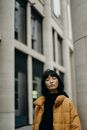 一个穿着黄色夹克的女人正在为城市建筑画肖像