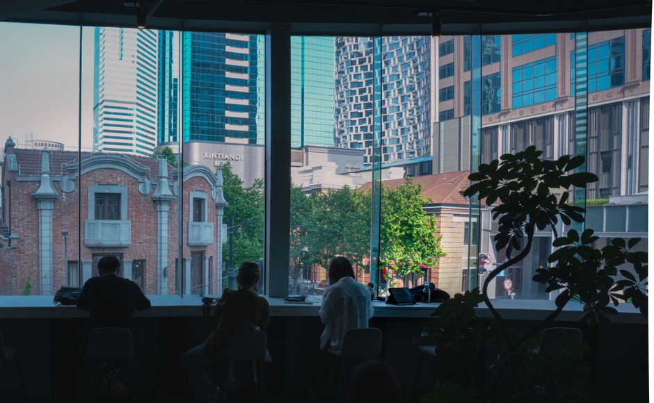 People working in a modern coworking space with panoramic city views in Xintiandi, Shanghai.