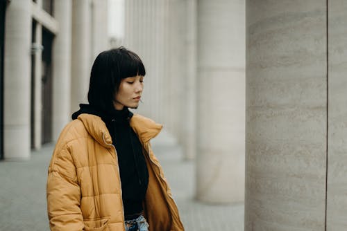 芥末黄泡泡全拉链外套摆姿势的女人的照片