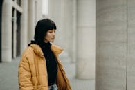 一个穿着休闲装的女人的肖像，沉思地看着城市环境