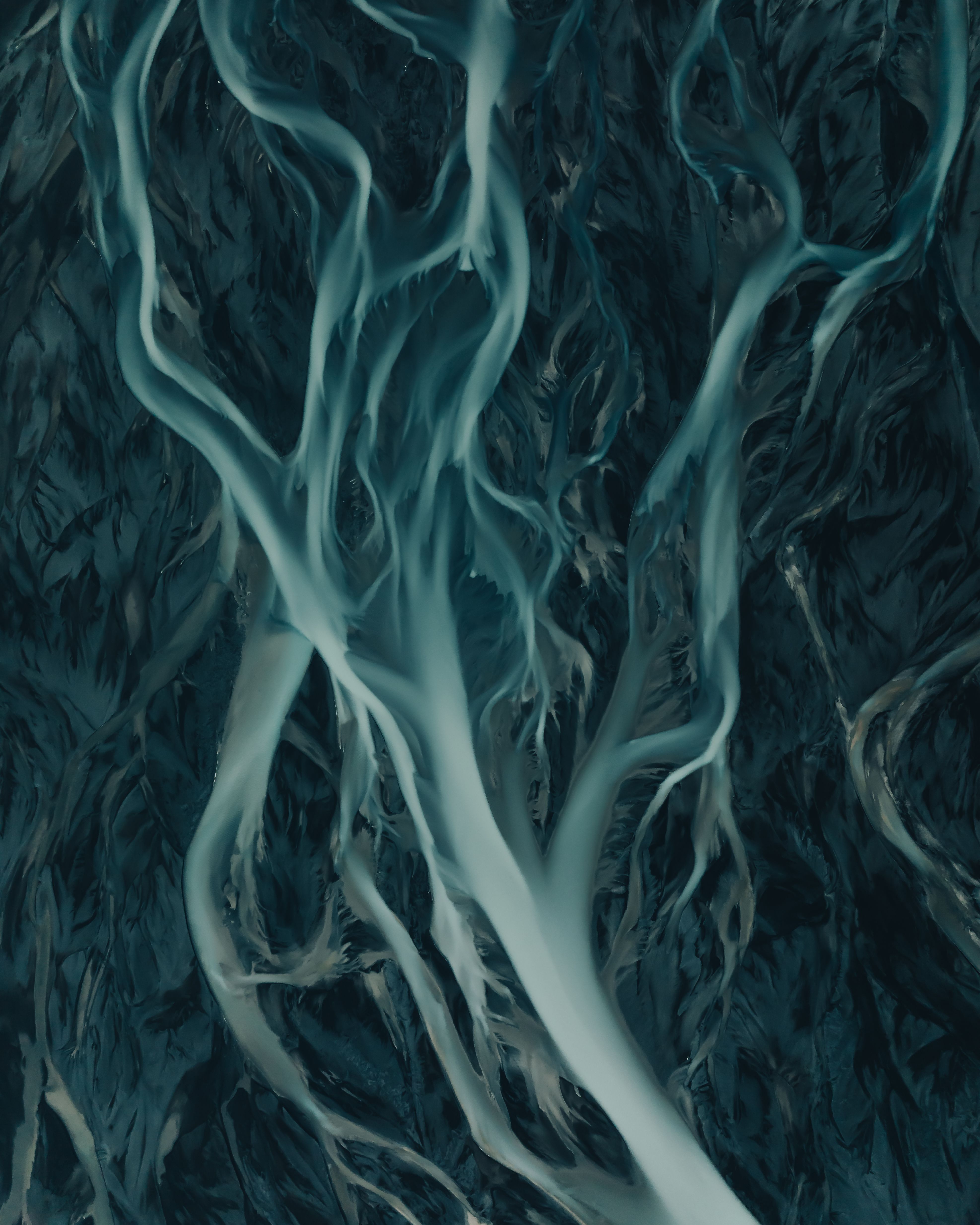 Stunning aerial view of a braided river system in Iceland showcasing intricate water patterns.