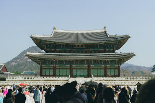 Explore the vibrant scene at Gyeongbokgung Palace, Seoul, capturing traditional Korean architecture and crowds in spring.