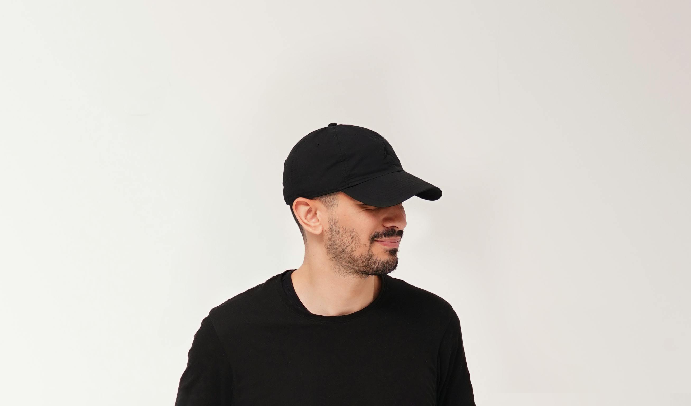 bezplatná Muž v černé čepici a tričku s minimálním pozadím, moderní styl. Základová fotografie