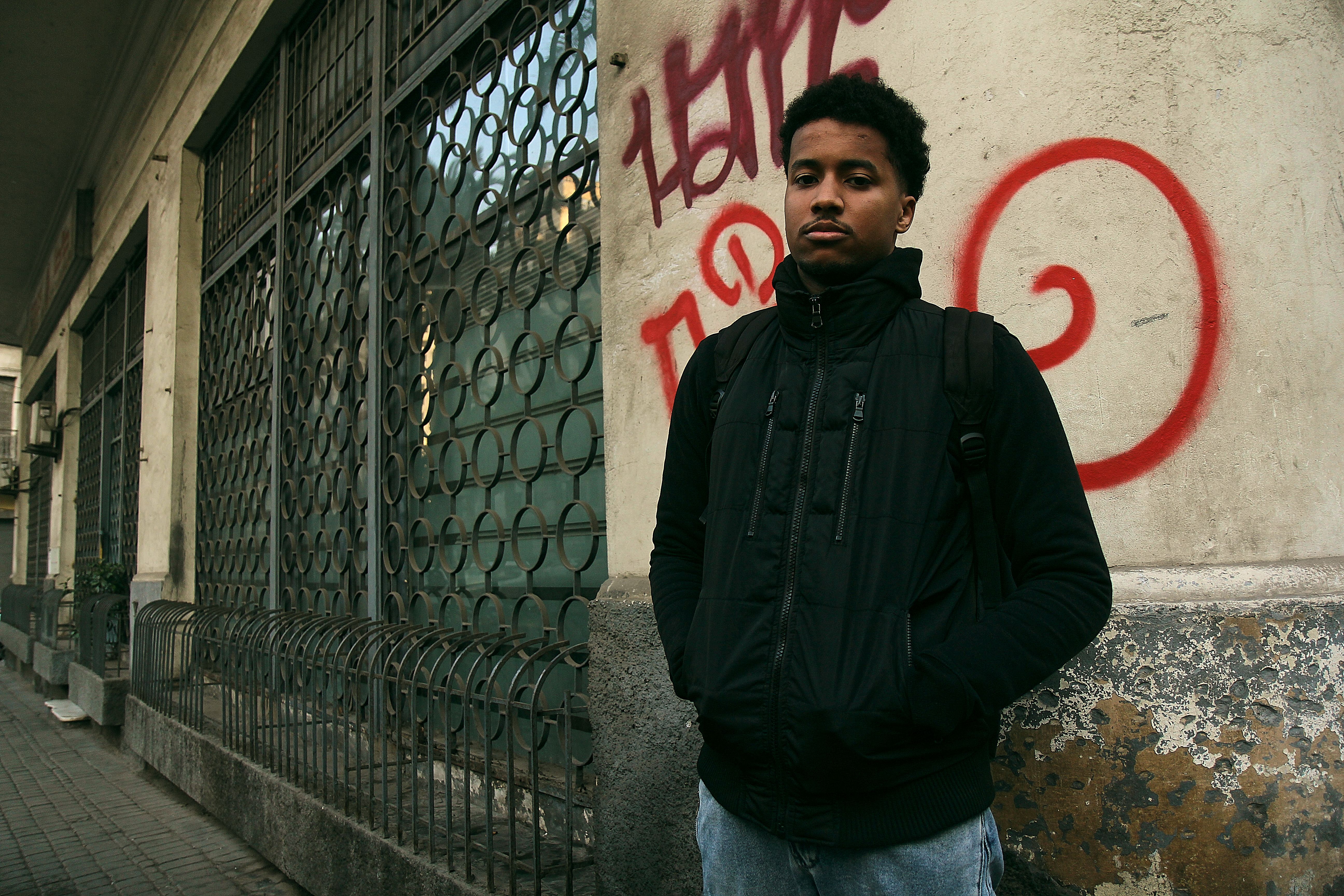 Urban Portrait of Young Man in Graffiti Alley · Free Stock Photo