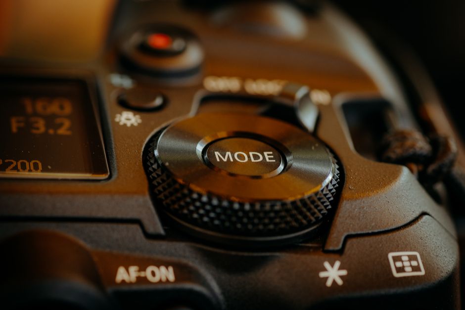 写真撮影の設定を示す、DSLR カメラのモード ダイヤルとボタンの詳細ビュー。