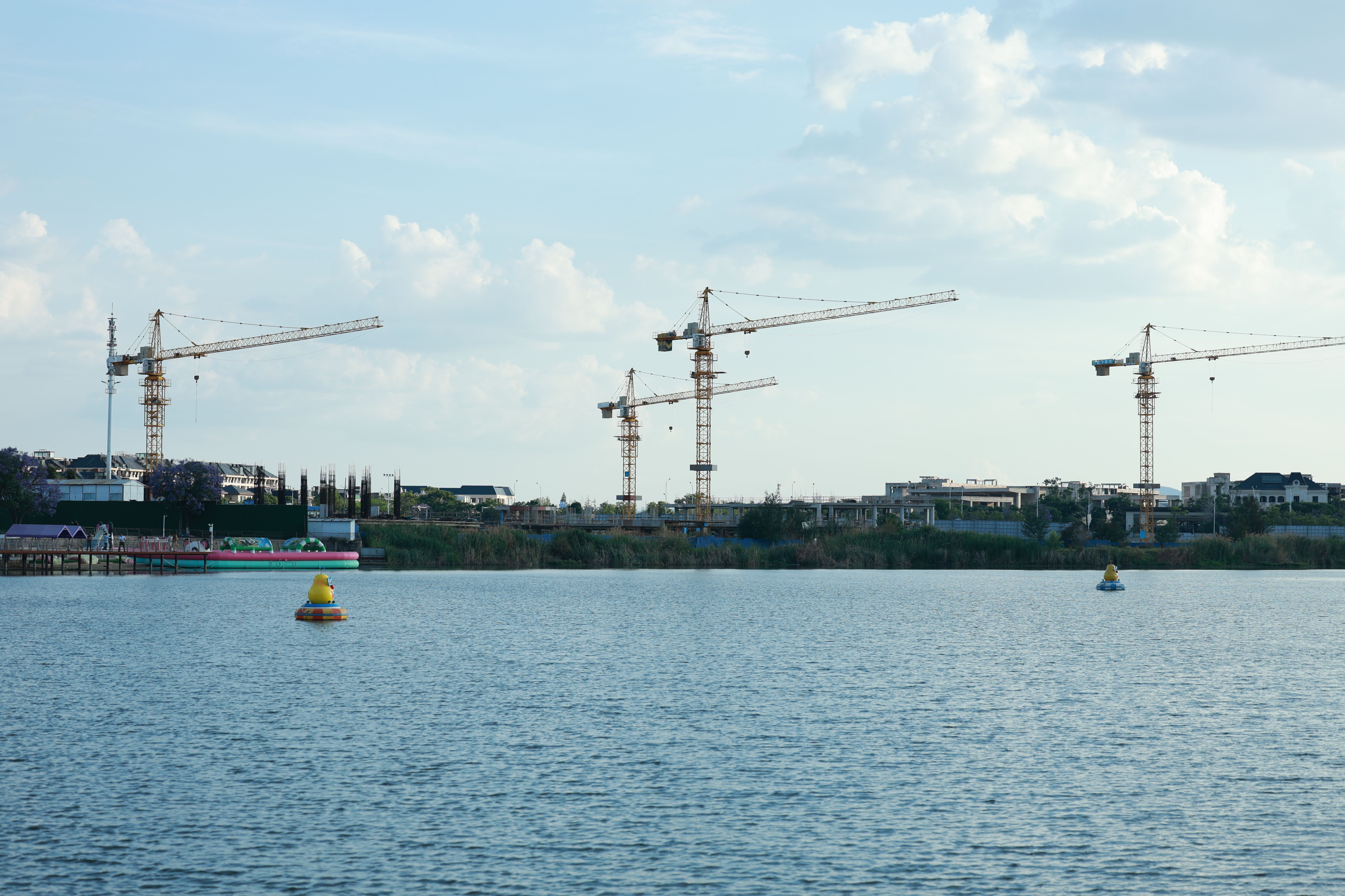Urban Development by Riverside with Construction Cranes · Free Stock Photo