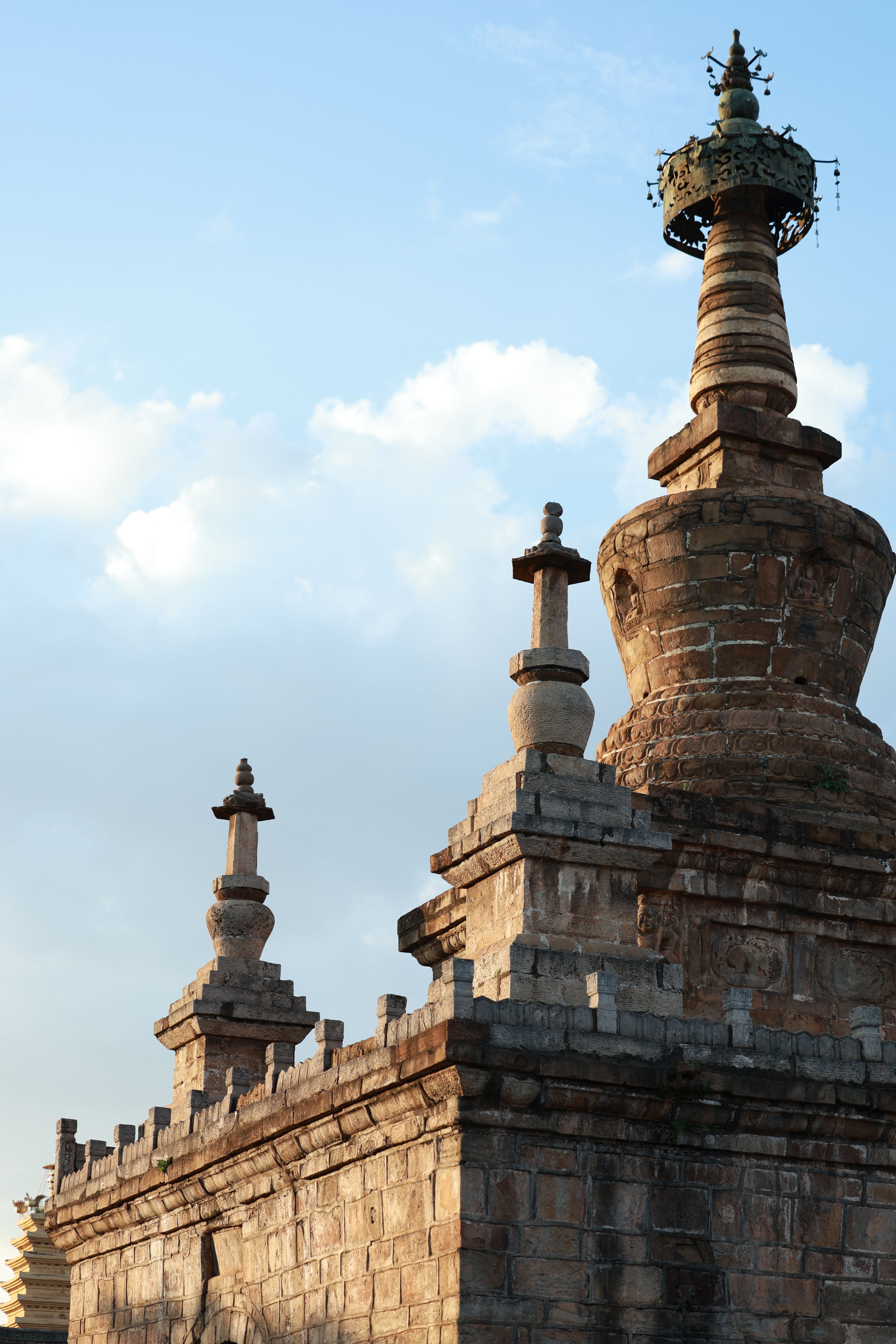 View of an ancient stone stupa silhouetted against a sunset sky, showcasing historic architecture.