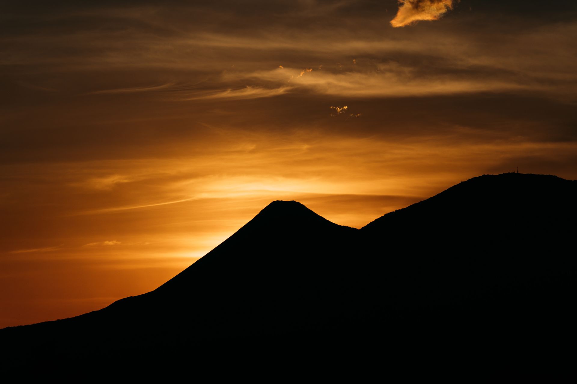 A breathtaking sunset silhouette of a volcano in El Salvador creates a dramatic and vibrant scene.