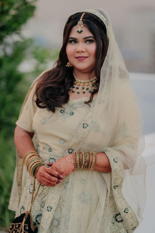 Free A beautiful bride in traditional South Asian dress with intricate jewelry and henna designs, outdoors. Stock Photo