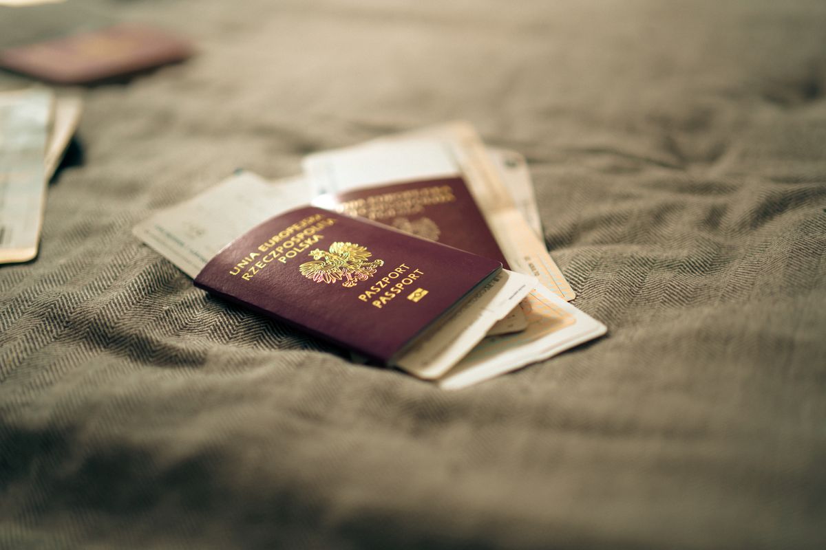 Passport and travel documents laid out on a table before an identity-card renewal application.