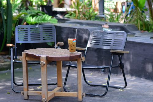 Free Tranquil outdoor café scene with chairs, table, and iced coffee. Stock Photo