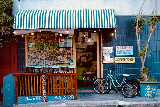 Cozy street cafe storefront with striped awning, bike, and eclectic signage.