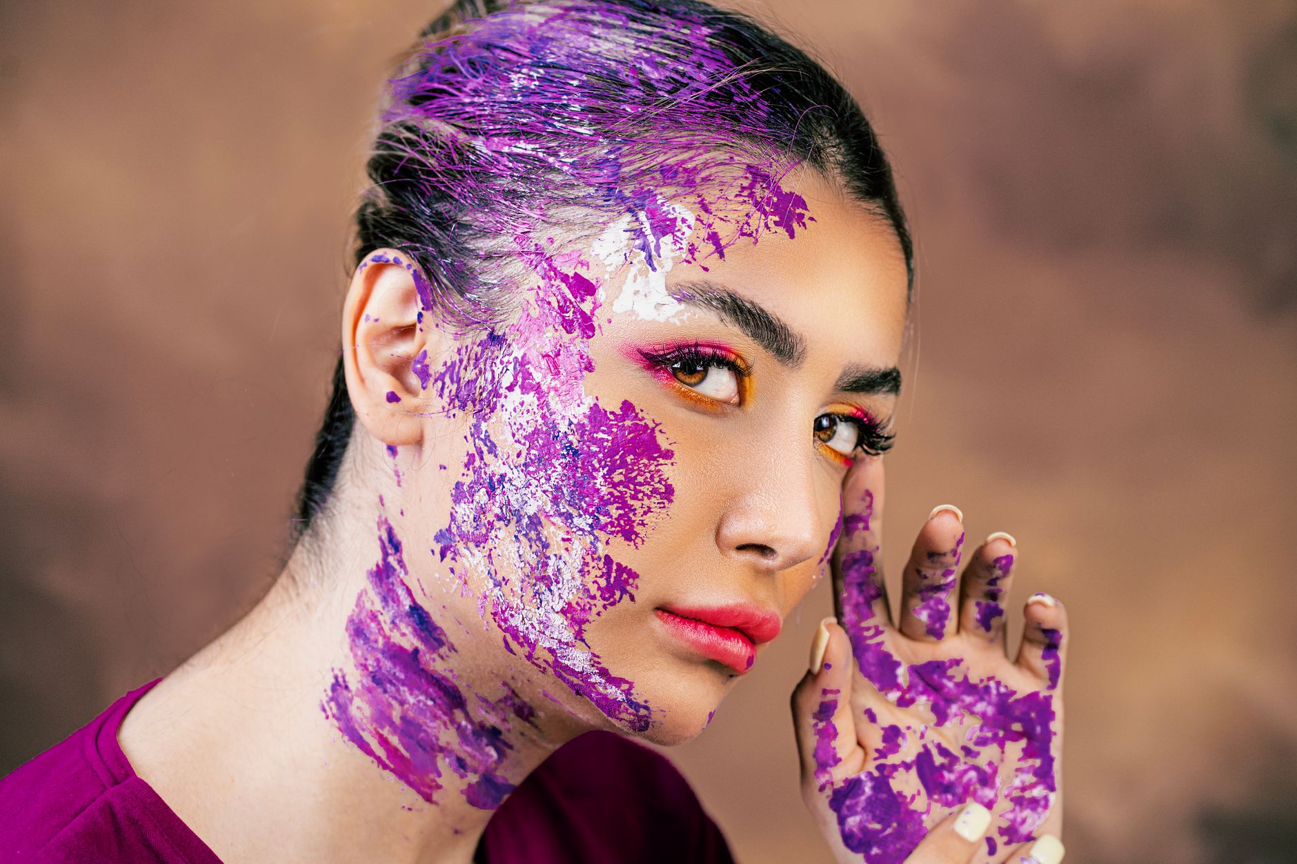 Crafted portrait of a woman with vibrant paint accents on her skin, eye-catching and creative.