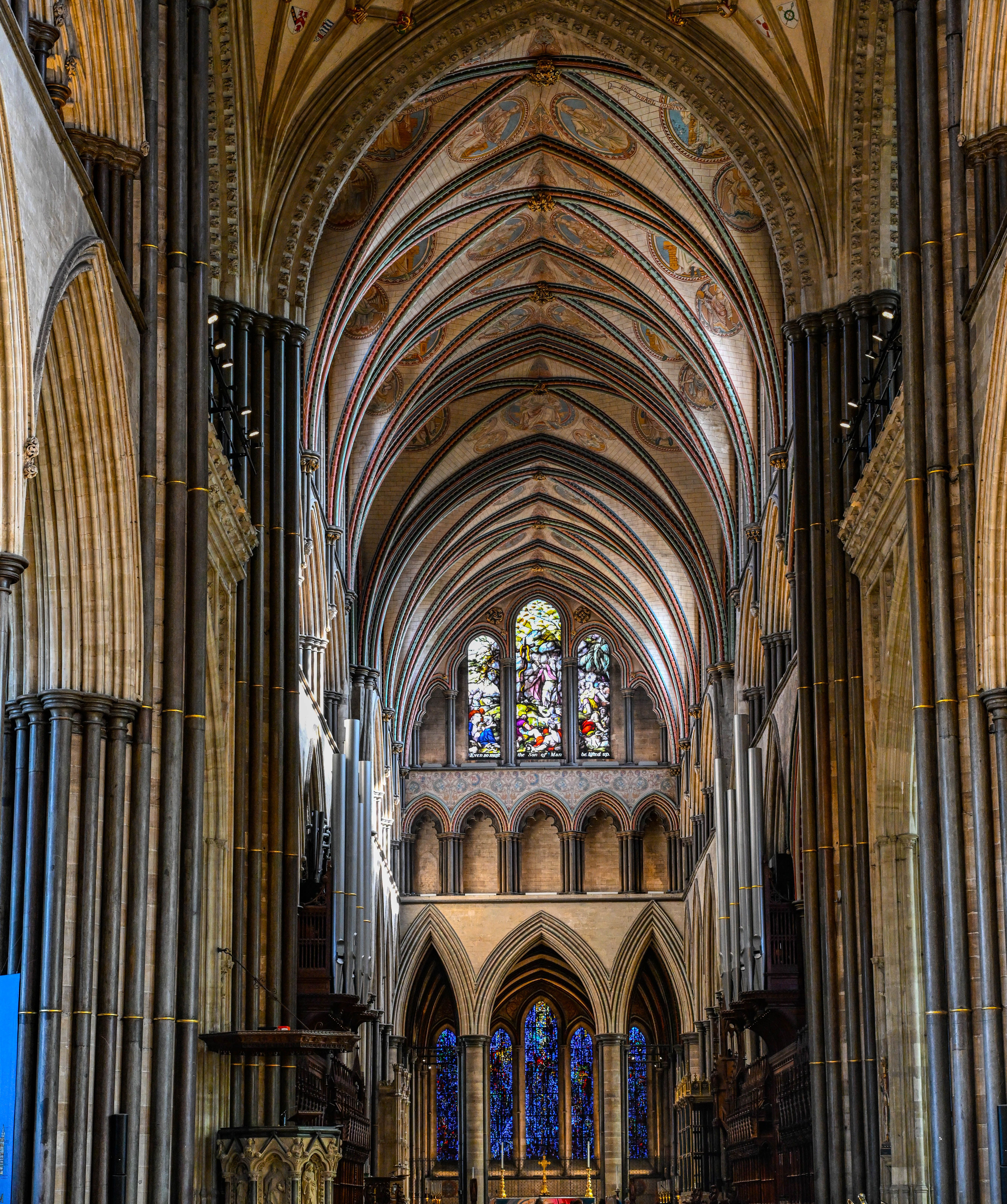 Majestic Gothic cathedral interior featuring stunning stained glass windows and vaulted ceilings.
