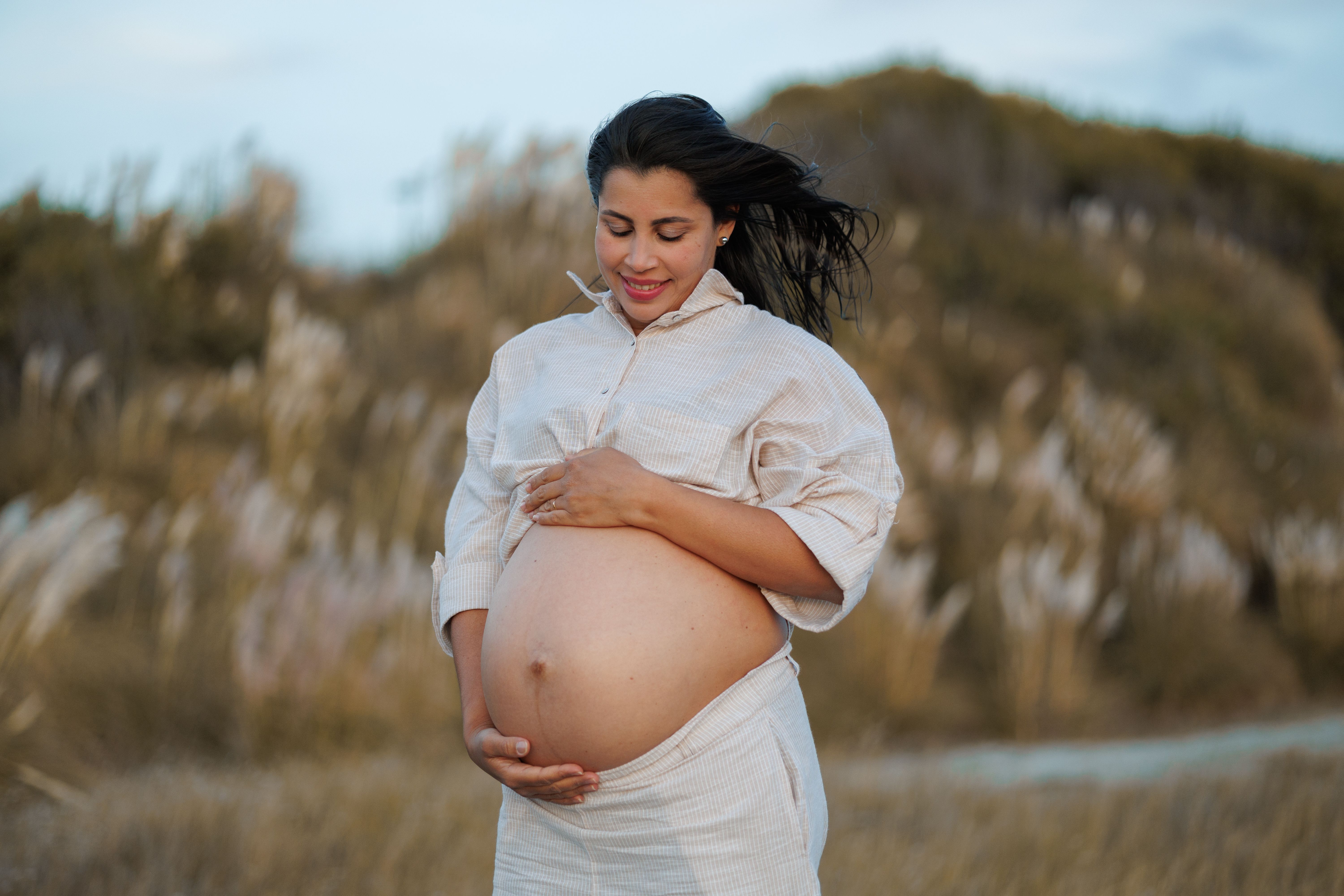 Expectant mother enjoying the serene outdoor setting, embracing her pregnancy journey beautifully.