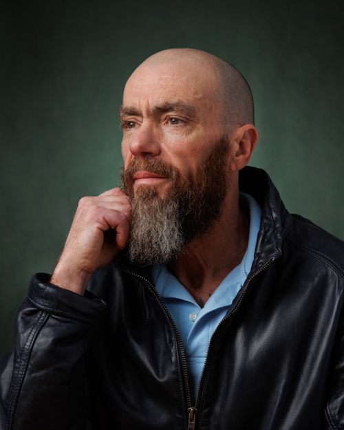 Free Captivating portrait of a bearded man in a thoughtful pose wearing a leather jacket. Stock Photo