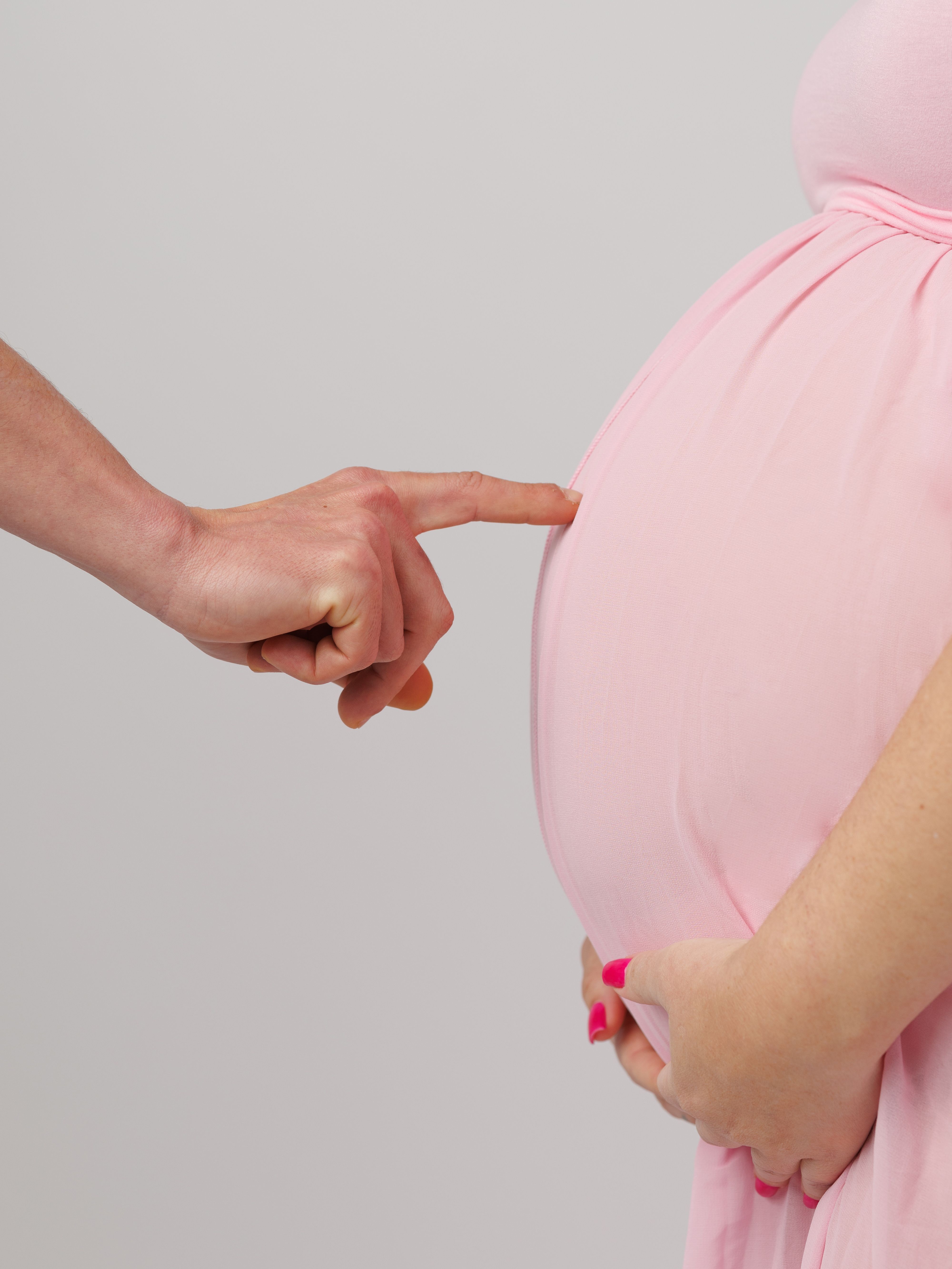 A gentle touch on a pregnant belly, symbolizing love and care during pregnancy.